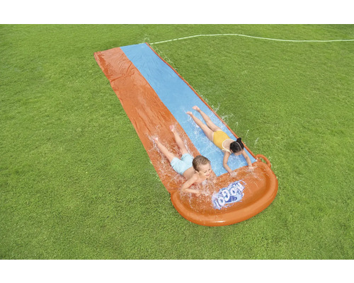 Nafukovací skluzavka s dětmi na zahradě.