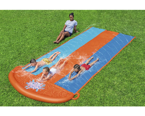 Vodní skluzavka s hrajícími si dětmi na zahradě