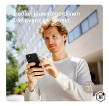 Muž ovládá své chytré rolety odkudkoliv na světě pomocí chytrého telefonu. (Image AI modified or generated)
