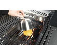 Sýrový burger se připravuje na grilu pod poklopem na tavení sýra