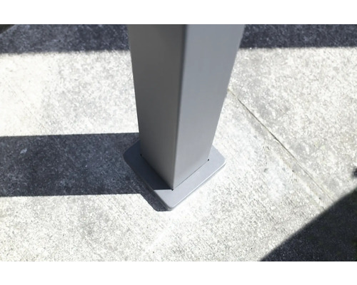 Detail šedé terasy stříšky upevnění sloupku na betonové podlaze.