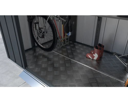 Interiér zahradního domku s kolem, holínkami a zahradním nářadím