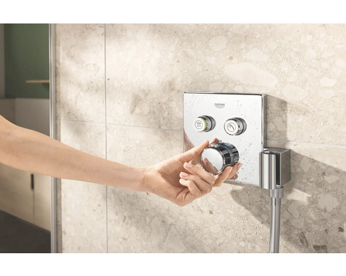 Ruka ovládá sprchovou baterii Grohe na zdi