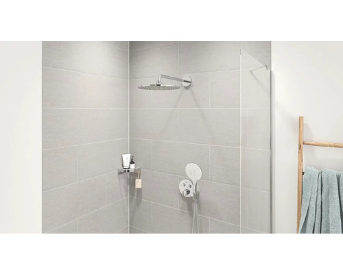 Moderní sprchový kout s dešťovou sprchou, ruční sprchou a úložnou policí na koupelnové doplňky.