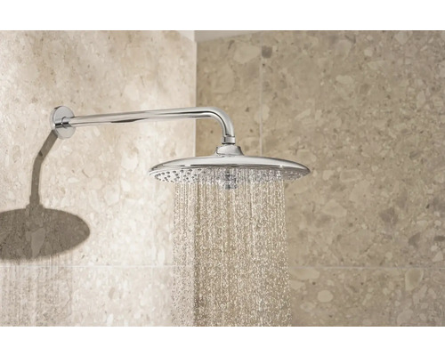 Dešťová sprcha s proudem vody namontovaná na stěně.