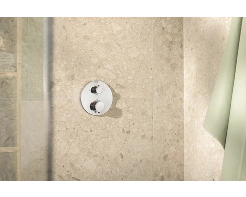 Logo Grohe na sprchové armatuře s kulatou deskou a dvěma otočnými knoflíky