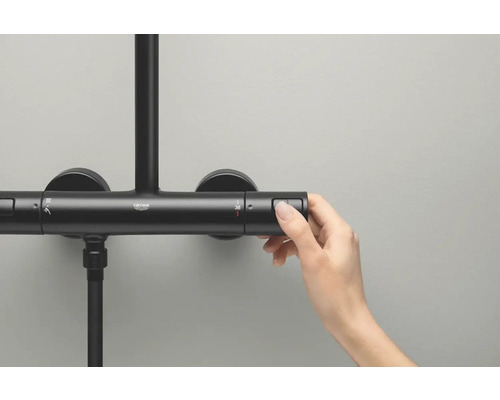 Detailní záběr ruky ovládající termostatickou sprchovou baterii Grohe