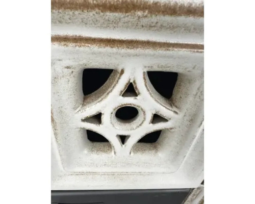 Detail bílého ozdobného prvku s geometrickým vzorem