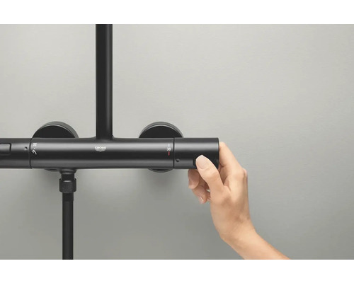 Fotografie ruky ovládající sprchový termostat Grohe