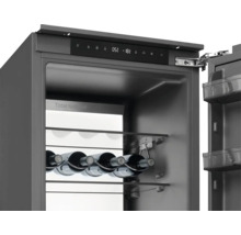 Detailní pohled na chladničku na víno se skleněnými policemi a lahvemi vína