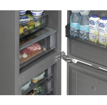 Vnitřní pohled na chladničku s různými potravinami na policích a v zásuvkách.