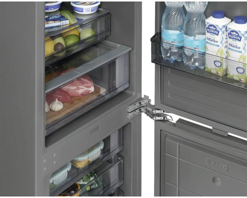 Vnitřní pohled na chladničku s různými potravinami na policích a v zásuvkách.