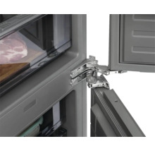 Detailní záběr chladničky s otevřenými dveřmi, viditelné jsou panty.