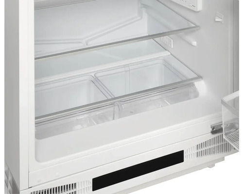 Vnitřní pohled na chladničku se skleněnými policemi a průhlednými nádobami