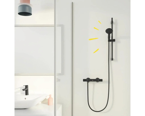 Černá sprchová souprava s tyčí a termostatem v koupelně.