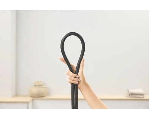 Ruka drží ohebnou černou hadici