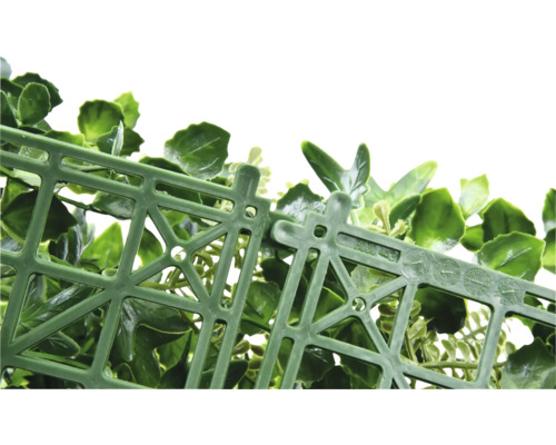 Detailní pohled na zelený umělý živý plot s plastovou mřížkou jako nosným materiálem.