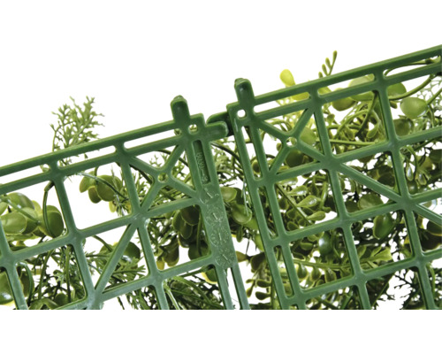 Detailní záběr plastové mřížky s upevňovacím mechanismem a zelenými okrasnými rostlinami.