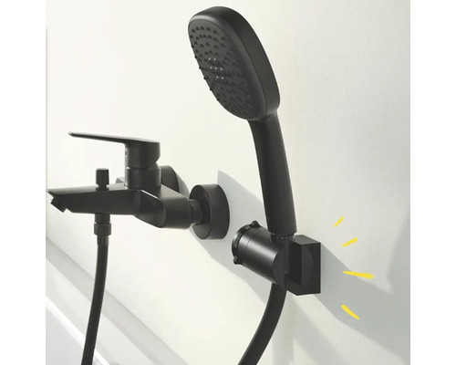 Černá vanová baterie s ruční sprchou a sprchovou hadicí namontovaná na stěně.