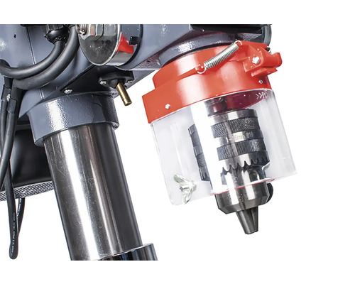 Detail sloupové vrtačky se sklíčidlem a ochranným zařízením.