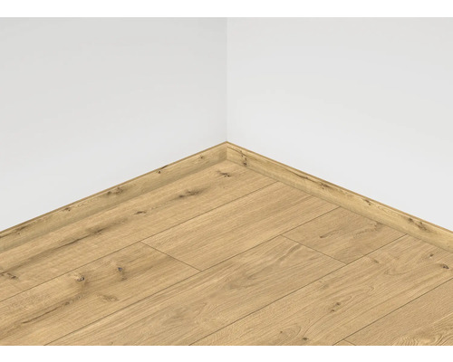 Položená laminátová podlaha s odpovídající podlahovou lištou u bílé zdi