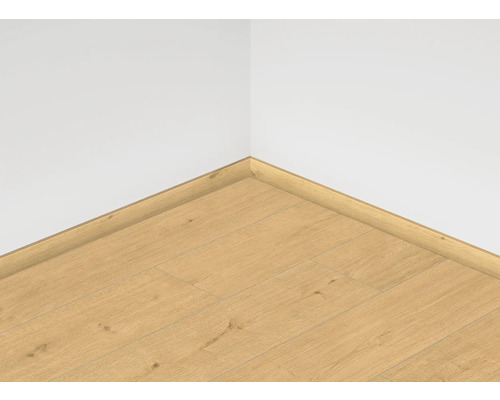 Roh místnosti s laminátovou podlahou a odpovídajícími soklovými lištami.