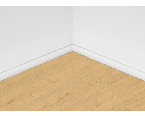 Rohový pohled na místnost s laminátovou podlahou a bílými podlahovými lištami