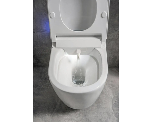 Bílé sprchovací WC s otevřeným víkem a tekoucí vodou