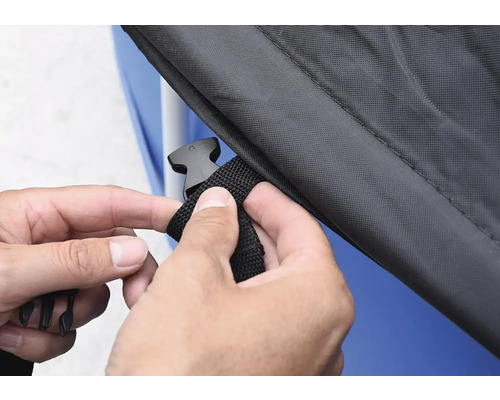 Osoba upevňuje kryt pomocí zacvakávacího uzávěru