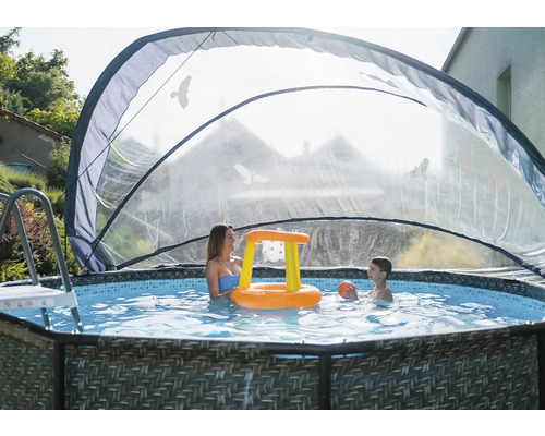 Scéna s bazénem se stříškou, ženou a dítětem hrajícími si s nafukovacím basketbalovým košem.