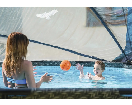Matka a dítě si hrají s míčem v bazénu se zastřešením.