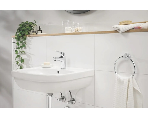 Koupelnové umyvadlo s baterií, kruhový držák na ručníky a dekorace na poličce