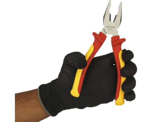 Kombinované kleště Stanley s izolovanými rukojeťmi v ruce s ochrannou rukavicí