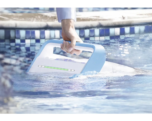 Ruka drží automatický čistič bazénu ve vodě