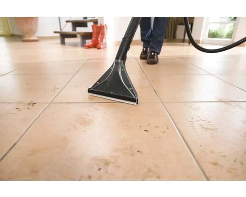 Čištění podlahy pomocí čisticího vysavače na dlaždicové podlaze