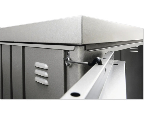 Detail kovového zahradního domku s větracími otvory a zajišťovacím mechanismem