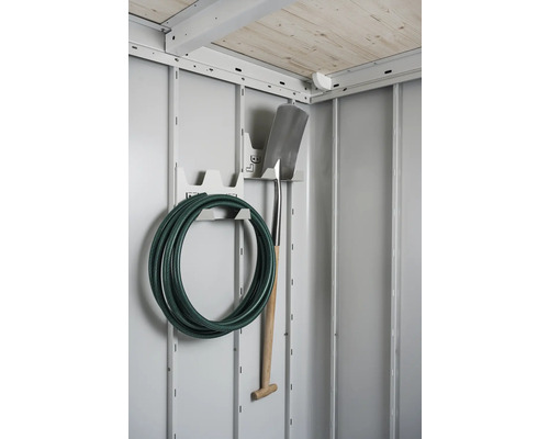 Zahradní hadice a rýč na držáku nářadí v zahradním domku