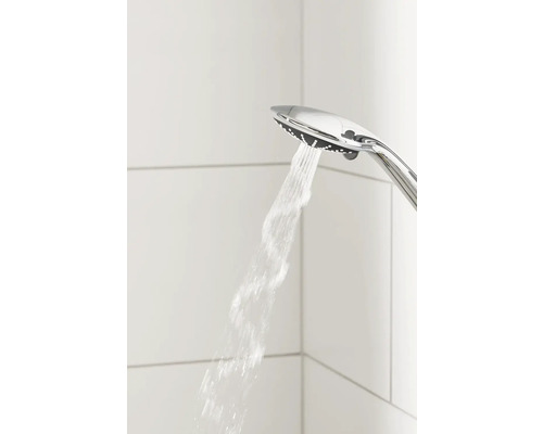 Sprchová hlavice s proudem vody na pozadí bílých dlaždic