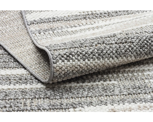 Detail šedo bílého pruhovaného koberce