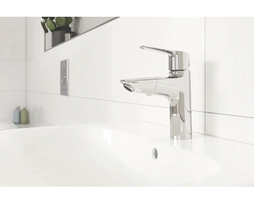 Moderní koupelna s umyvadlem na desku a chromovanou pákovou baterií.