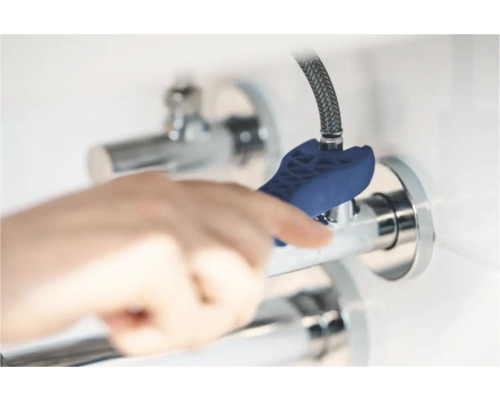 Ruka používá klíč na vodovodní baterie k montáži vodovodní baterie.