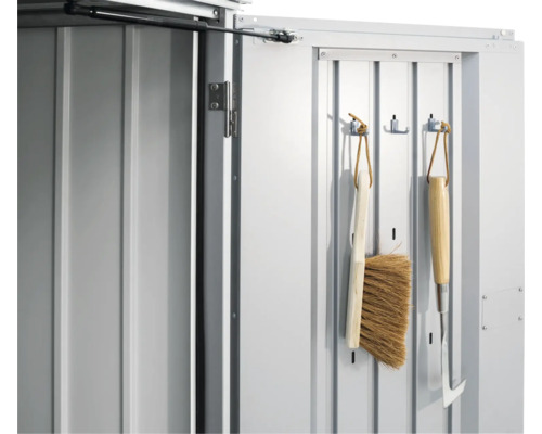 Detailní pohled na dveře zahradního domku s zahradním nářadím na hácích