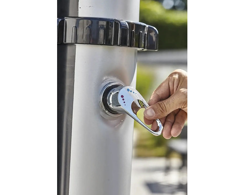 Ruka ovládá vodovodní kohoutek zahradní sprchy