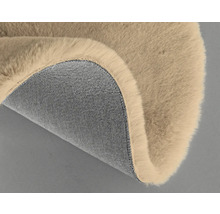 Detail béžového koberce s chlupatým povrchem a textilní spodní stranou