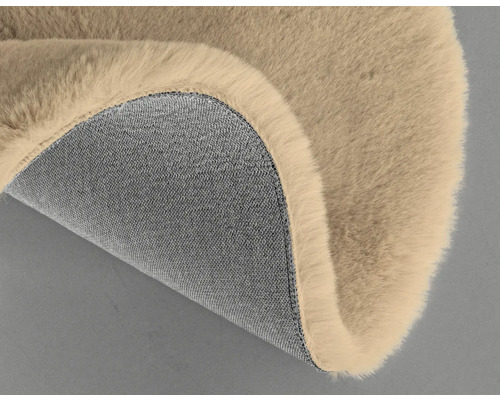 Detail béžového koberce s chlupatým povrchem a textilní spodní stranou