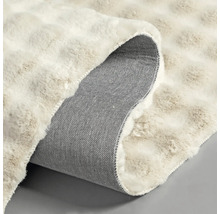 Detailní pohled na koberec s vlasem a tkanou zadní stranou.