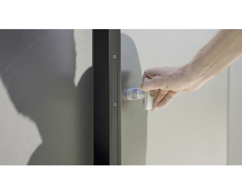 Ruka ovládá kliku kovových dveří.