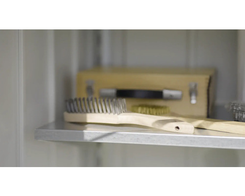 Drátěný kartáč s dřevěnou rukojetí na polici.