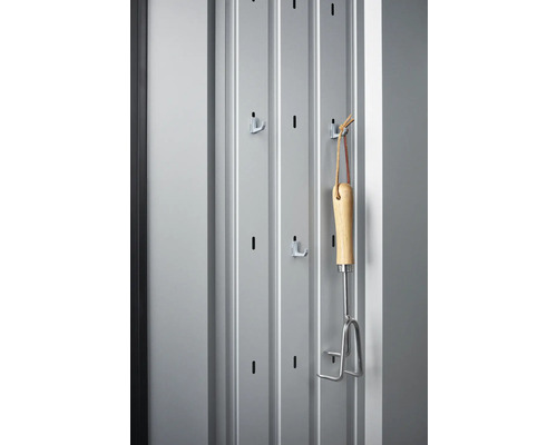 Kovová stěna s háčky a zahradním nářadím