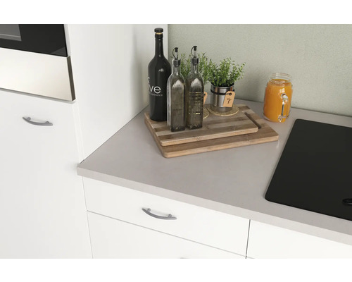 Kuchyňské zátiší s lahvemi, bylinkami, prkénky a varnou deskou